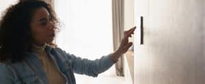 woman looking at thermostat confused